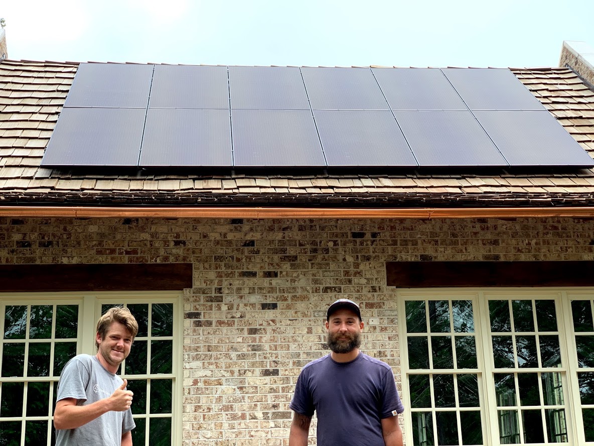 Man walk on house roof and installs solar panels. Photovoltaic, alternative and renewable energy, green power, ecology and home electricity production.